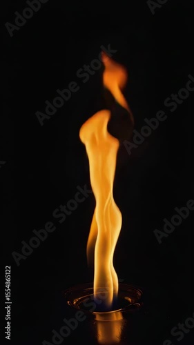 A realistic single flame slowly rising upward in dramatic slow motion, isolated on a dark background for visual impact.