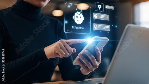 Woman using smartphone with holographic AI assistant interface beside a laptop in a modern workspace. Concept of artificial intelligence, virtual help and digital productivity tools