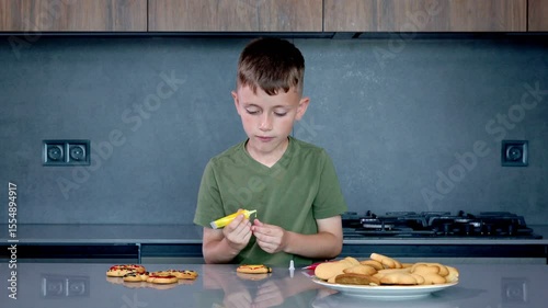 A focused child joyfully bakes colorful cookies with fun cutters and soft dough in a warm, creative kitchen