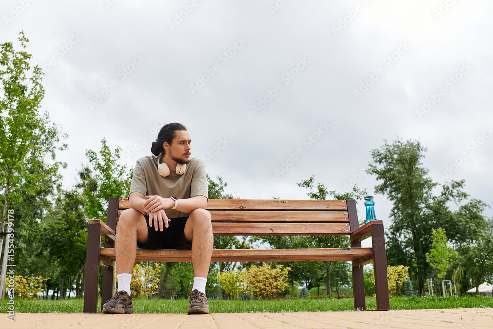 Fototapeta premium Sporty young man enjoying outdoor workout time in a lush green park setting