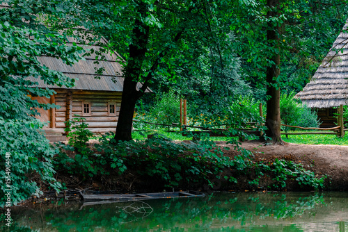 natural space rural settlement wooden log houses near lake and in trees environment in summer time