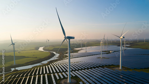 Aerial view of wind turbines and solar panels in a field with a river on a sunny day landscape scene