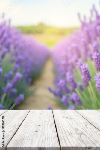 Blurred blooming lavender field with wooden tabletop. Natural floral background for product mockup or presentation