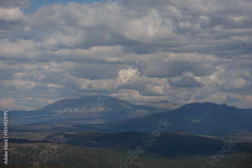 Many cumulus clouds over the hills. Mountain landscape.
