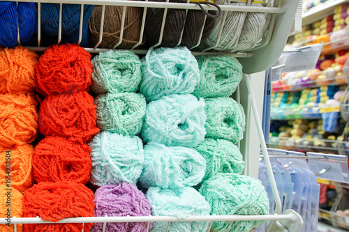 Balls and bundles of multicolored yarn on store shelves.