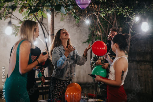 A lively gathering of young friends enjoying a celebration outdoors with colorful balloons and festive decor, highlighting joy and camaraderie in an outdoor setting.