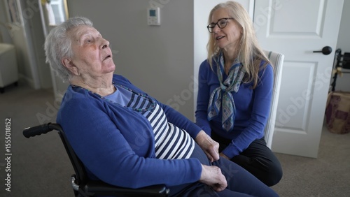 A daughter lovingly engages with her elderly mother in a cozy home setting, demonstrating care and support during a visit that highlights family connections.