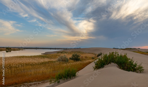 A sand dune on the shore of the Wooden Lake in the Almaty region of southeastern Kazakhstan on a cloudy evening