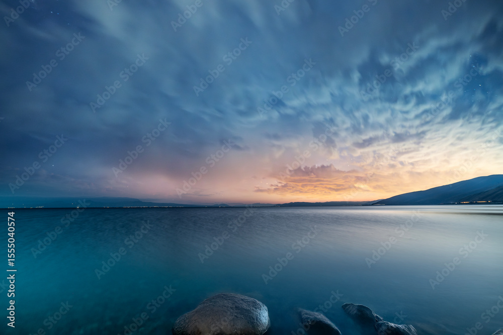 Naklejka premium Beautiful night landscape, long exposure clouds over the lake. Starry night. 