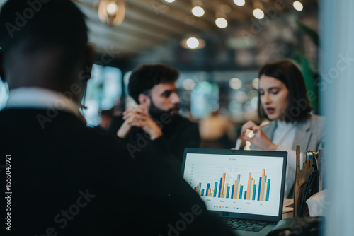Valokuva Multicultural businesspeople collaborating and analyzing sales data in a dynamic workplace environment
