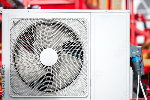 A white air conditioner with a blue and red background