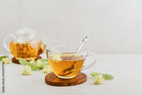 Glass cup of linden tea with glass teapot