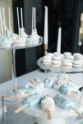 Elegant Blue and White Dessert Table with Cake Pops, Macarons, and Candied Treats for a Special Event