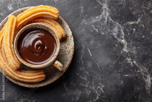 Churros with chocolate are served on a decorative plate and marble surface