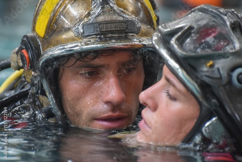 Firefighters provide aid to an individual in water, showcasing teamwork and lifesaving skills during a training exercise at a facility