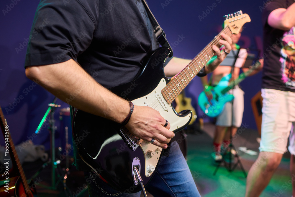 Fototapeta premium An Energetic and Enthralling Guitar Performance by Trendy Musicians on a Vibrant Stage