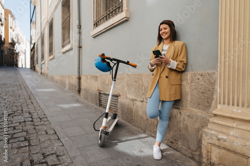 Asian woman using e scooter and app while exploring new city