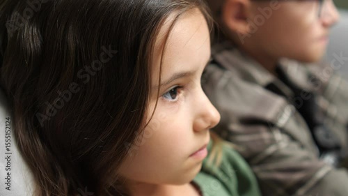 Portrait of pensive little girl sitting next to her brother