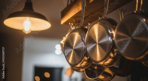 Hanging stainless steel pots in cozy kitchen lighting