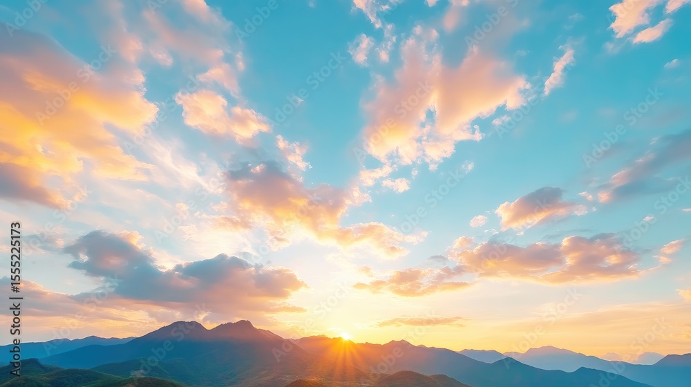 Obraz premium Panoramic sunset view over mountain range. Soft colors, hazy clouds