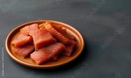 Smoked Arctic char jerky air-dried with lichen and sea salt served on a burnt orange plate
