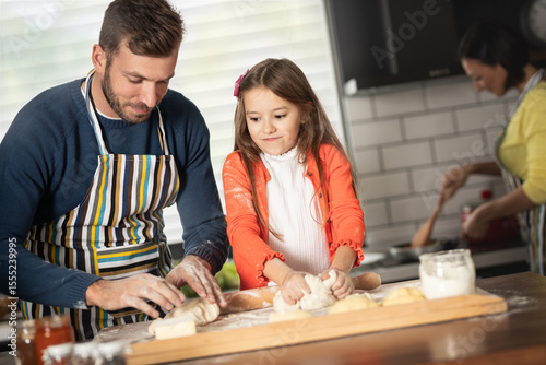 A child helps the father in the kitchen