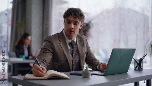 Company worker creating project noting ideas in copybook at workplace closeup