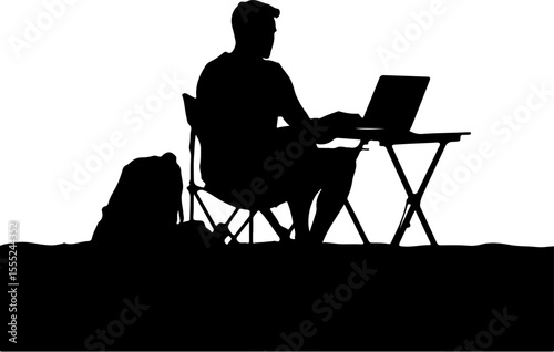 silhouette of a man sitting on a chair and using laptop
