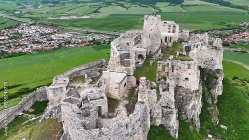4K cinematic drone view of ancient castle ruins in Slovakia with national flag on tower. Perfect for travel, history and heritage projects.