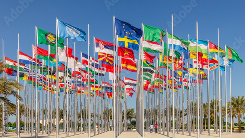 Many world's countries national flags waving on the wind, with UN, EU, GCC, Sweden, Serbian banners in the foreground, Doha, Qatar
