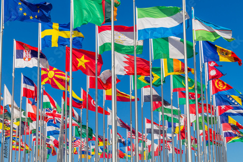 Lots of world's countries national flags waving on the wind, with Sweden, Serbian, Macedonian, Tajik, Bahrain, Nigerian Moldavian banners in the foreground, Doha, Qatar
