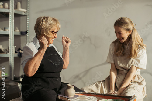 Konstfotografi Senior woman celebrating pottery success with instructor