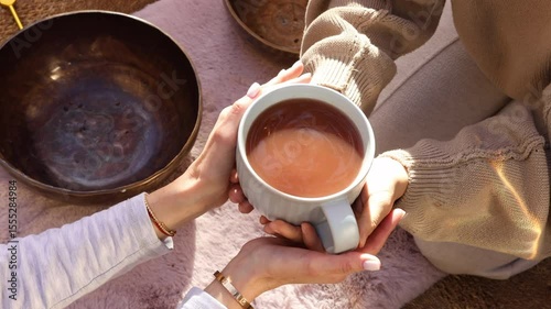 Overhead shot of hands passing a tea cup from one person to another