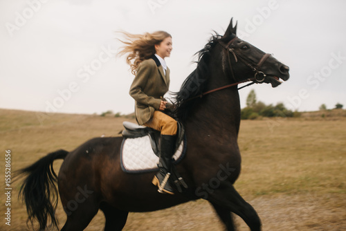 Woman Riding Horse Across Open Field on a Windy Day