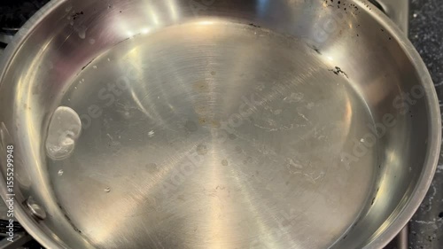 Hot water beginning to boil in a stainless steel pan