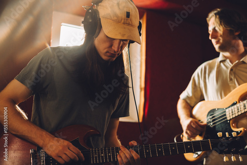Musicians playing guitars and recording music in studio