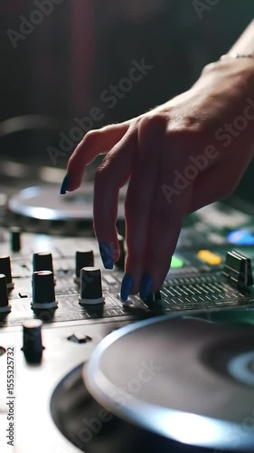 In a dimly lit nightclub, a DJ expertly manipulates the crossfader and jog wheels on a professional audio mixer—skillful hands crafting the perfect sound.