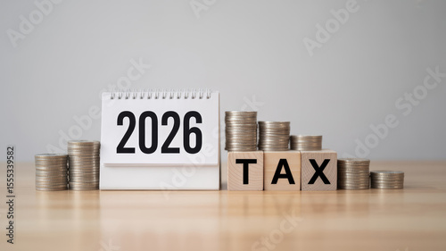 A calendar with the year 2016 on it and a pile of coins and wooden blocks on top of it