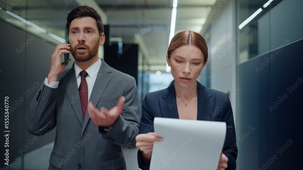 Confident boss talking mobile phone walking vestibule with secretary closeup Confident boss talking mobile phone walking vestibule with secretary closeup