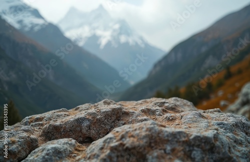 Close-up rock surface mountains. Blurred background mountain landscape with snow peaks, green slopes, valley. Scenic outdoor nature. Ideal for product display background. Promote travel, adventure,