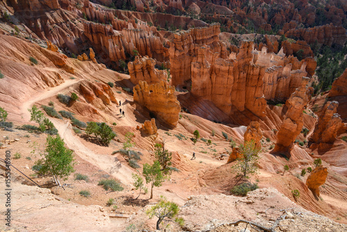 View from canyon rim of rock hoodoos and people on the queens loop hiking trail, summer vacation exploring in Bryce Canyon National Park, Utah
