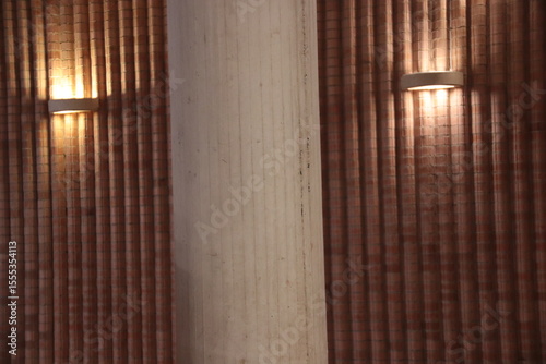 Canvas Print Modern wall lamp illuminating a red brick wall with warm downward light