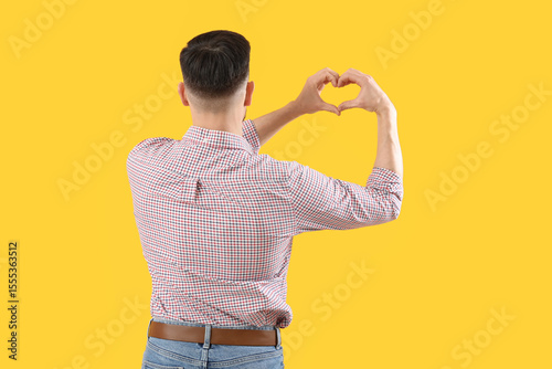Handsome man making heart w...