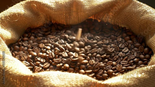 Jute sack brimming with fresh roasted coffee beans, some falling