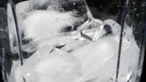 Ice chunks inside a clear blender pitcher, slightly frosty looking