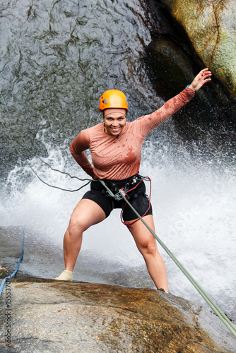 Canvas Print Latin american woman wearing helmet and safety harness enjoying canyoneering, ra