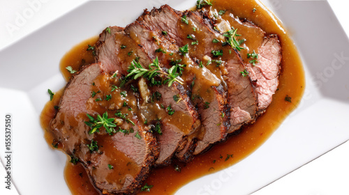 Tender sliced roast beef with savory gravy, garnished with herbs on a white plate.