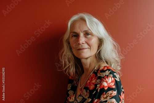 Portrait of a senior woman on a red background. The concept of pensioners and lifestyle.