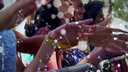 Front-row music festival attendees responding to music at barricade, clapping with graphic overlay