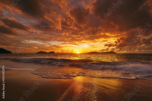 Dramatic Golden Sunset Over Tropical Ocean with Island Silhouettes and Reflective Beach